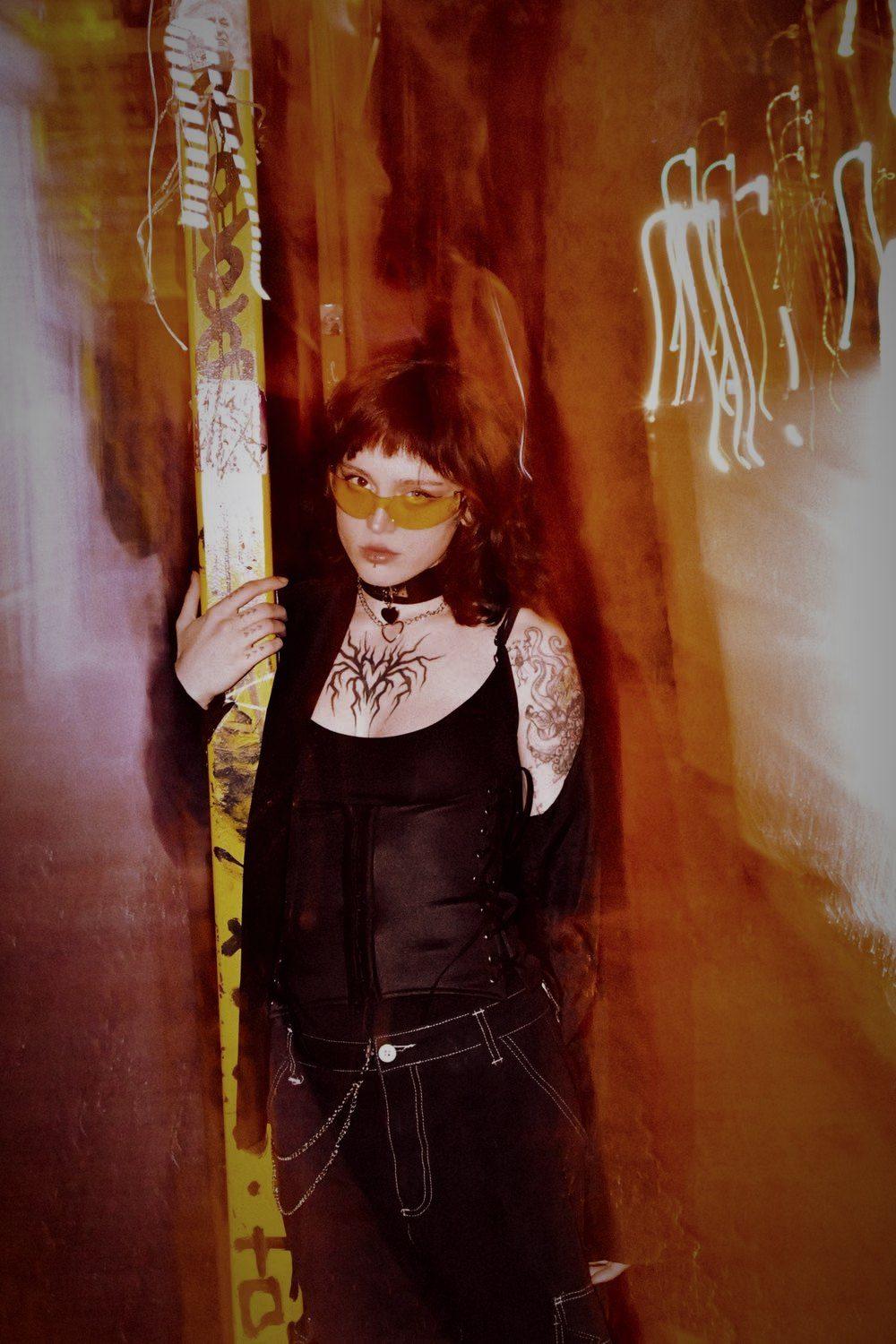 Tattooed model in a red neon alley