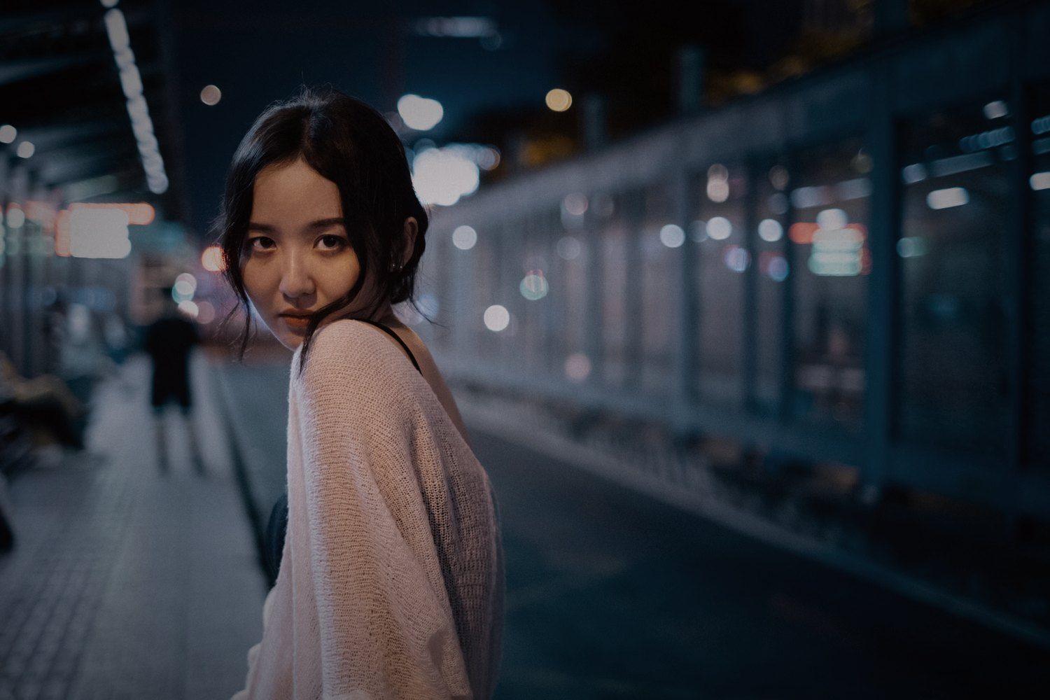 Model looking back on a blue night street