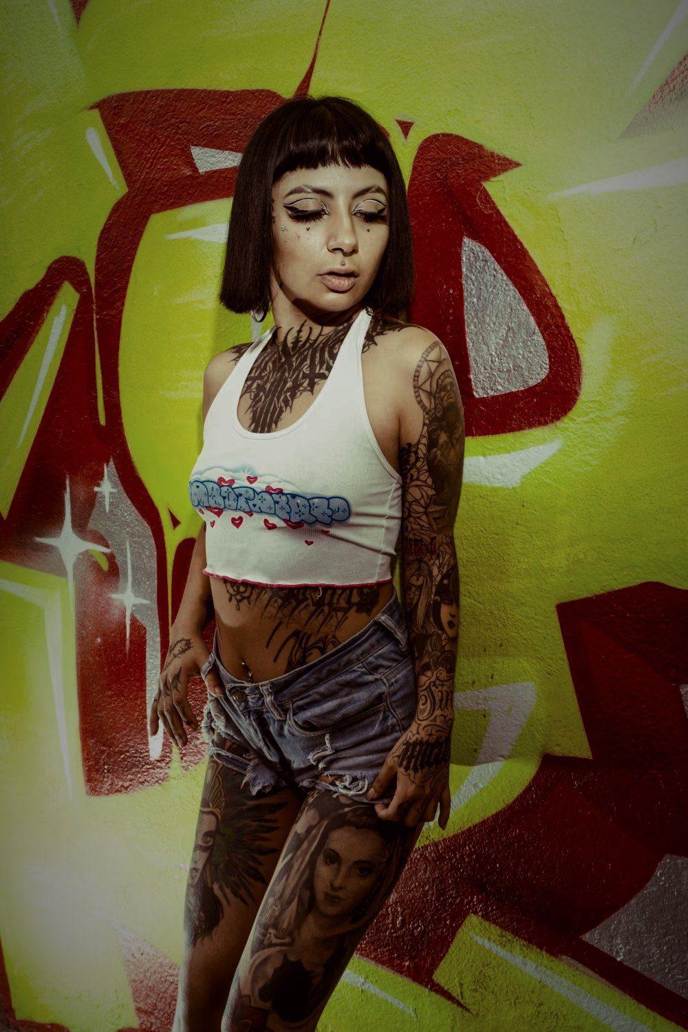Tattooed model against graffiti